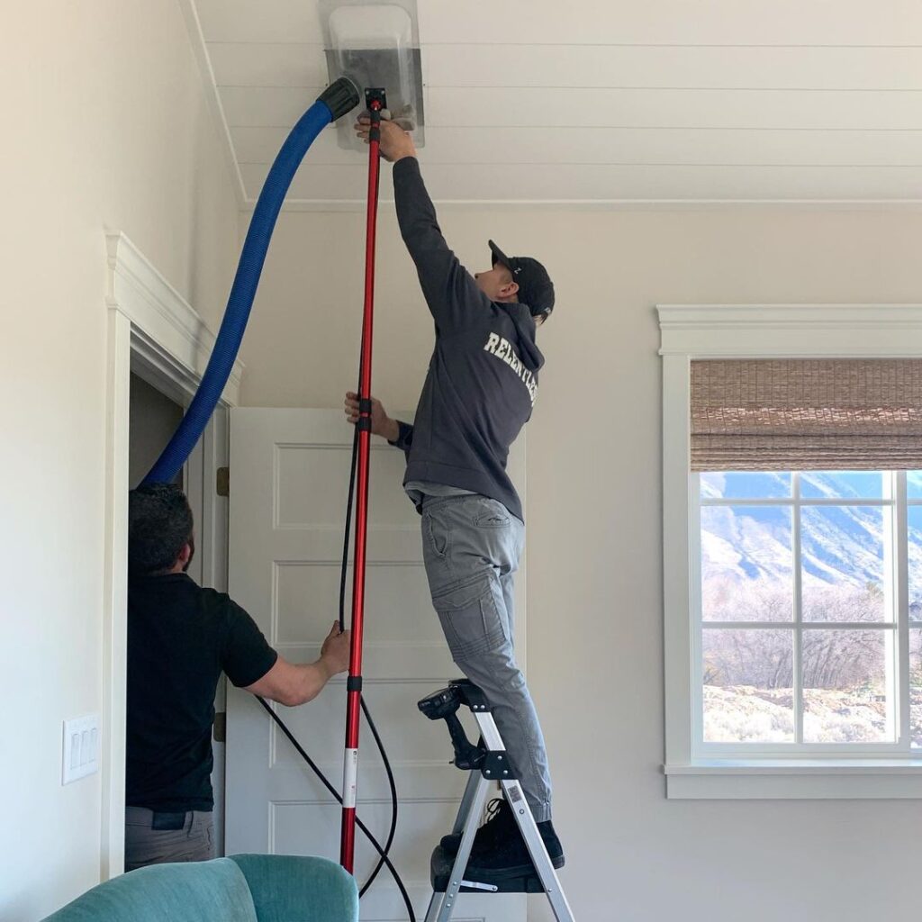 Worker cleaning an air duct